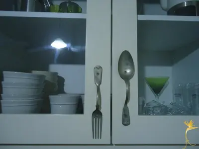 a kitchen cabinet with a fork and spoon in it at A Casa Estrelícia-Dourada Garcês in São Vicente