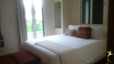 a bedroom with a white bed with a window at A Casa Estrelícia-Dourada Garcês in São Vicente