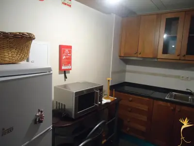 a kitchen with a refrigerator and a tv on a counter at A Casa Estrelícia-Dourada Garcês in São Vicente