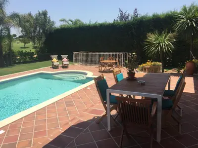 a table and chairs next to a swimming pool at 4 bed 4 bathroom villa Quinta da Boavista in Lagos