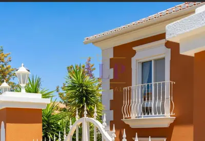 a house with a balcony and a palm tree at 4 bed 4 bathroom villa Quinta da Boavista in Lagos