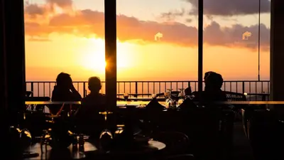 a group of people sitting at tables watching the sunset at Palheiro Village Resort in Funchal