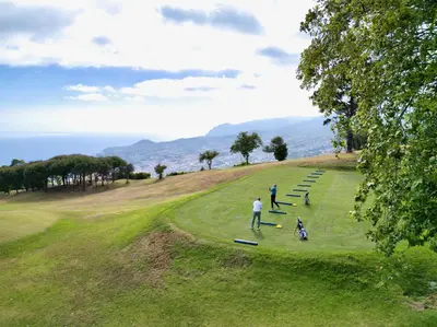 a group of people playing frisbee in a field at Palheiro Village Resort in Funchal