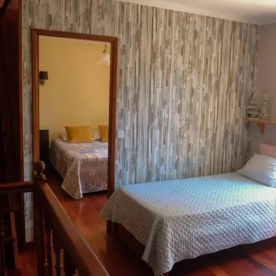 a bedroom with two beds and a mirror at Casa da Guida in Paul do Mar
