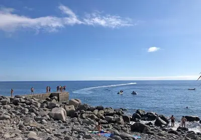 a group of people in the water at a beach at Casa da Guida in Paul do Mar