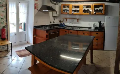 a kitchen with a black counter top in a room at Casa da Guida in Paul do Mar
