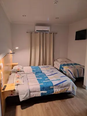 a bedroom with two beds and a desk and a window at Residencial Melba in Funchal