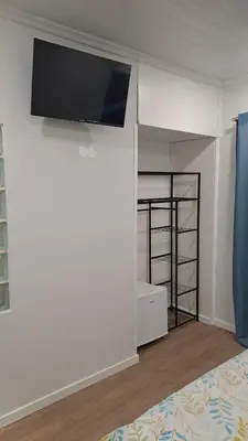a bedroom with a bed and a tv on a wall at Residencial Melba in Funchal