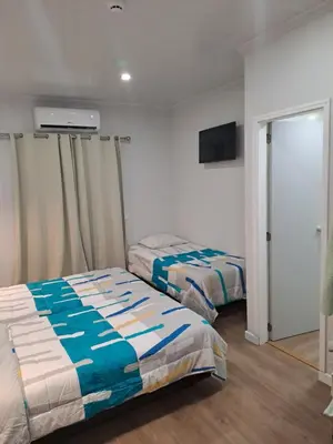a bedroom with two beds and a flat screen tv at Residencial Melba in Funchal