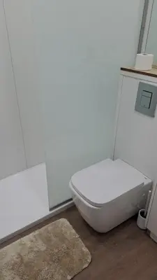 a bathroom with a white toilet and a rug at Residencial Melba in Funchal