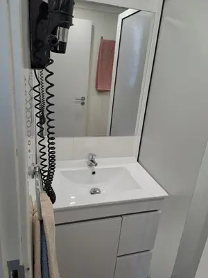 a bathroom with a sink with a mirror and a phone at Residencial Melba in Funchal