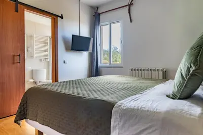 a bedroom with a large bed with a window at Casa Os Manos in Santana