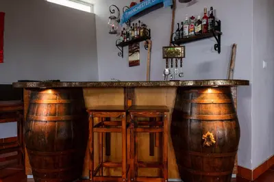 a bar with two wooden stools and a large barrel at Casa Os Manos in Santana
