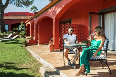 a man and woman sitting at a table outside of a house at Boutique Hotel Vivenda Miranda in Lagos