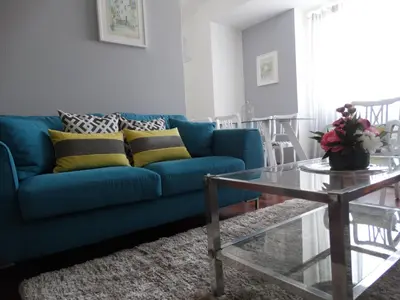 a blue couch in a living room with a glass table at Barreirinha Funcho House in Funchal