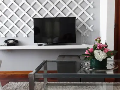 a living room with a tv and a glass table at Barreirinha Funcho House in Funchal