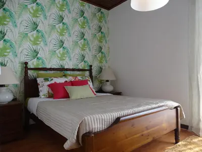 a bedroom with a bed with a floral wallpaper at Barreirinha Funcho House in Funchal