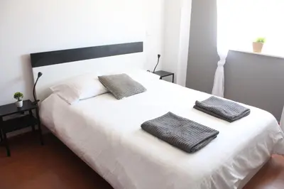 a bedroom with a white bed with two pillows on it at Lilas' Private Accommodation in Vila do Bispo