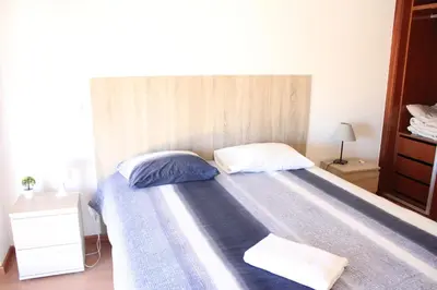 a bed with two pillows on it in a bedroom at Lilas' Private Accommodation in Vila do Bispo