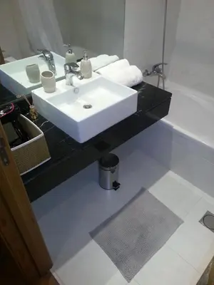 a bathroom with a white sink and a bath tub at Jardim das Madalenas in Funchal