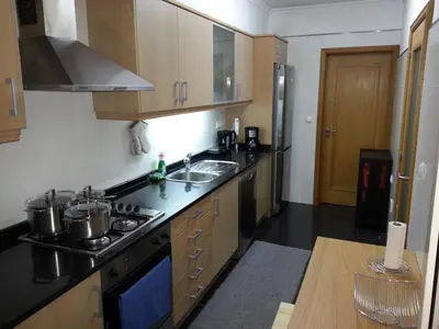 a kitchen with a sink and a stove top oven at Jardim das Madalenas in Funchal