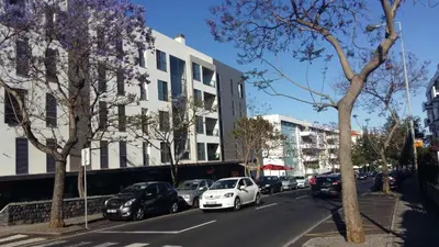 a white car parked on the side of a city street at Jardim das Madalenas in Funchal