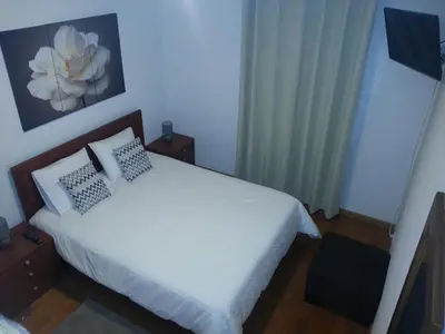 a bedroom with a white bed with two pillows at Jardim das Madalenas in Funchal