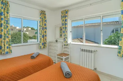a bedroom with two beds and a window at Casas do Ramalhete in Luz