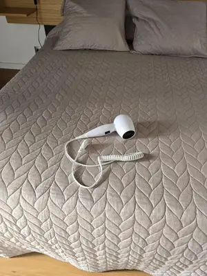 a bed with a white comforter with a mouse on it at AL Moniz in Machico