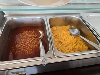 a lunch box with beans and gravy and spoons at AL Moniz in Machico