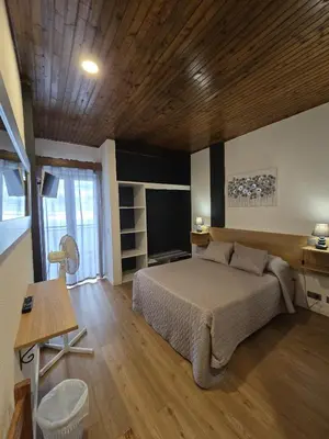 a bedroom with a bed and a television in it at AL Moniz in Machico