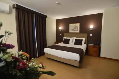 a hotel room with a bed and a large window at Hotel Salgueiro in Porto Moniz