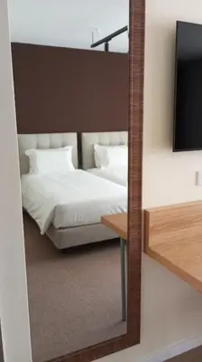 a bedroom with a white bed and a mirror at Hotel Salgueiro in Porto Moniz