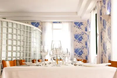 a dining room with a table with wine glasses at Amparo in Machico
