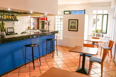 a bar in a restaurant with tables and stools at Amparo in Machico