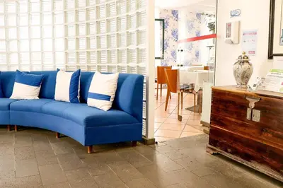 a blue couch with white pillows in a living room at Amparo in Machico