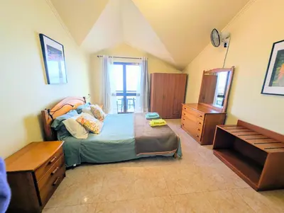 a living room with a yellow couch and a kitchen at Paul do Mar BY SEA in Paul do Mar