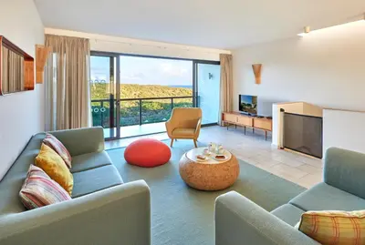 a living room with a couch and a tv at Martinhal Sagres Beach Family Resort Hotel in Sagres