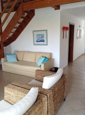a living room with a couch and two ottoman at Casa Trinta - Praia da Arrifana in Praia da Arrifana
