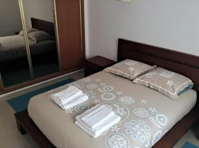 a bed with towels and a mirror in a room at Casa Trinta - Praia da Arrifana in Praia da Arrifana