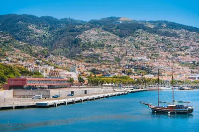 a boat sitting in the water next to a dock at Pestana CR7 Funchal in Funchal