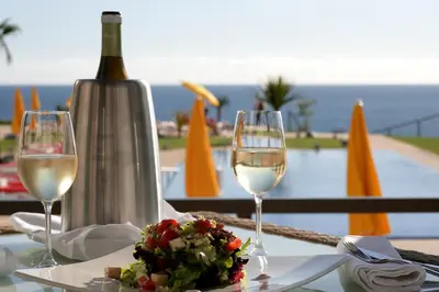 a table with two glasses and a bottle of wine at Golden Residence Hotel in Funchal