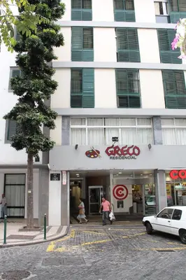 a white building with a car parked in front of it at Residencial Greco in Funchal