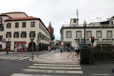 a busy city street with people walking on a crosswalk at Residencial Greco in Funchal