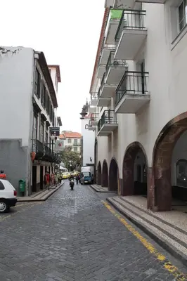 a cobblestone street in a city with buildings at Residencial Greco in Funchal
