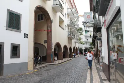 a couple of people walking down a street at Residencial Greco in Funchal