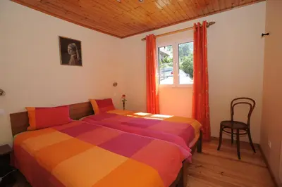 a bedroom with a colorful bed and a window at Casa Daniela in Calheta