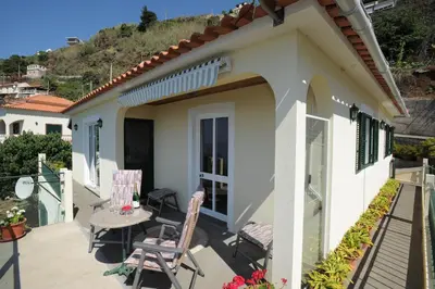 a patio of a house with two chairs and a table at Casa Daniela in Calheta