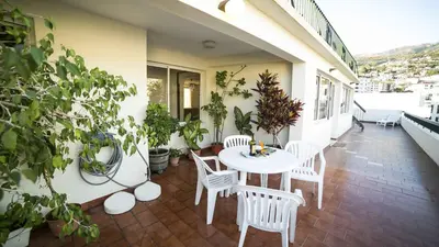 a patio with a table and chairs on a balcony at Hotel Sirius in Funchal