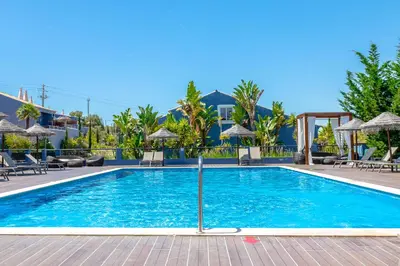 a swimming pool at a resort with chairs and umbrellas at Aldeia Azul Resort in Lagos